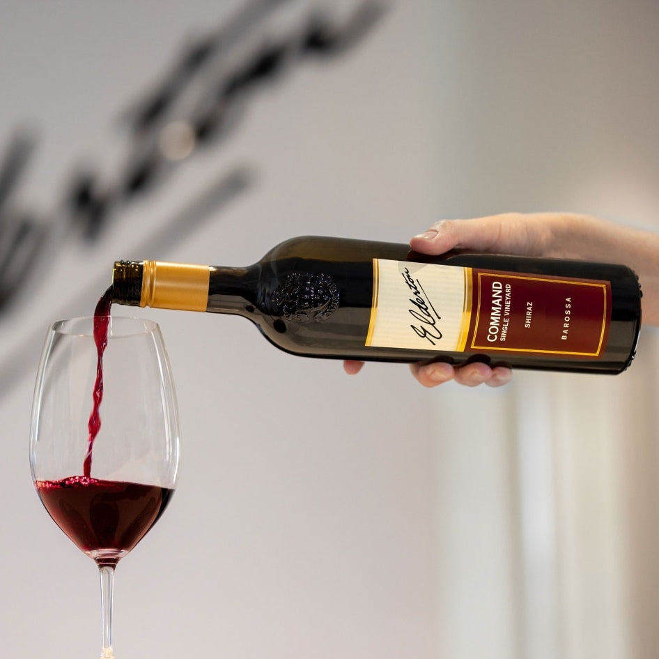 Bottle of Elderton-Command-Shiraz wine being poured into a glass with a blurred background
