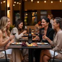 Load image into Gallery viewer, Four women enjoying a meal and Elephant Hill STONE Syrah wine at an outdoor restaurant.