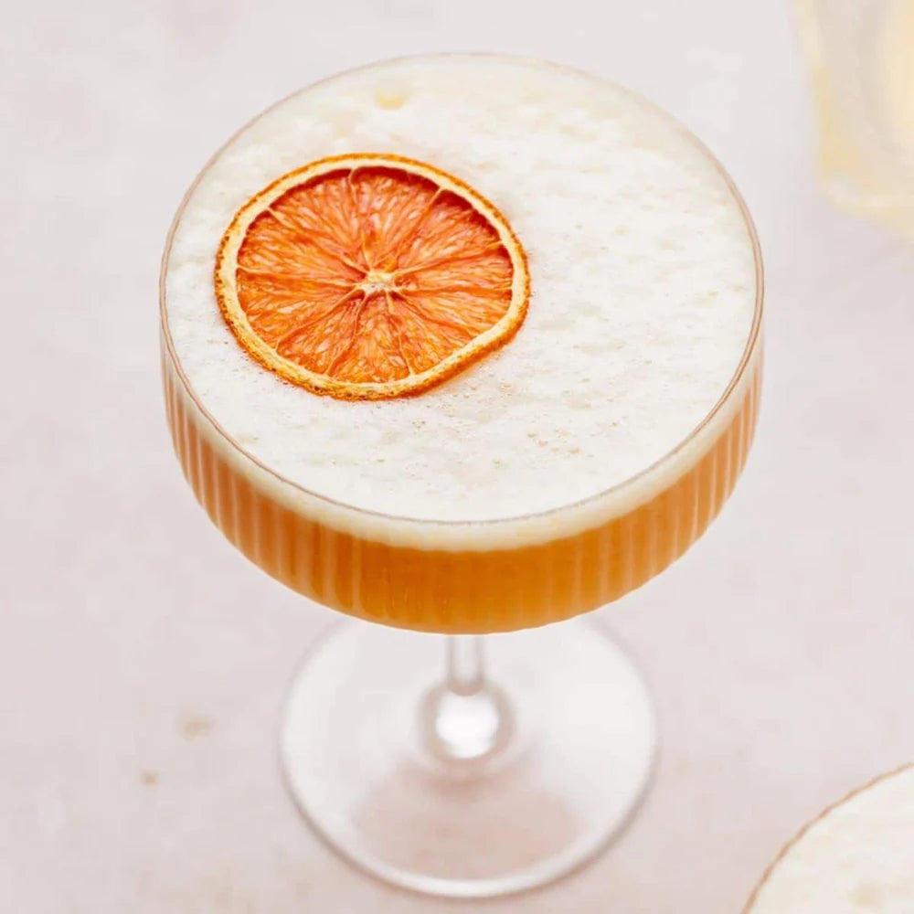 Load image into Gallery viewer, Cocktail with a dried orange slice on a light background