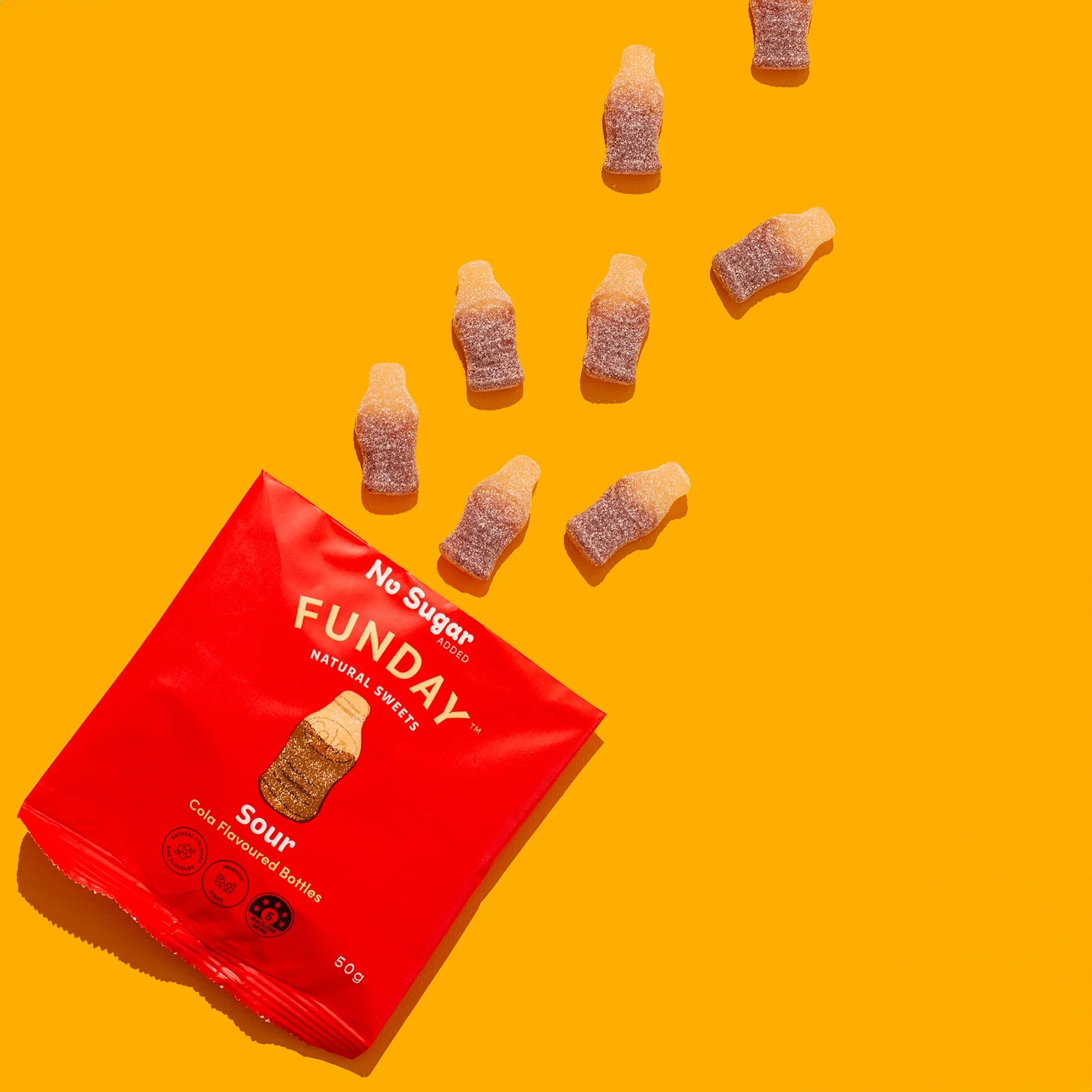 Load image into Gallery viewer, Red package of 'FUNDAY' no sugar Cola flavoured bottle gummies on a yellow background
