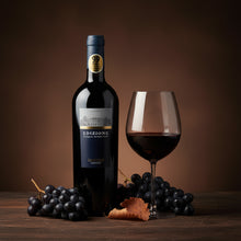 Load image into Gallery viewer, A bottle of Farnese Fantini Edizione Cinque Autoctoni red wine next to grapes and galss