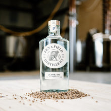 Load image into Gallery viewer, Fen &amp; Field Distillery gin bottle on a wooden surface with seeds around