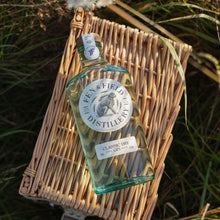 Load image into Gallery viewer, Fen &amp; Field Distillery gin 
bottle on a woven tray in a grassy field