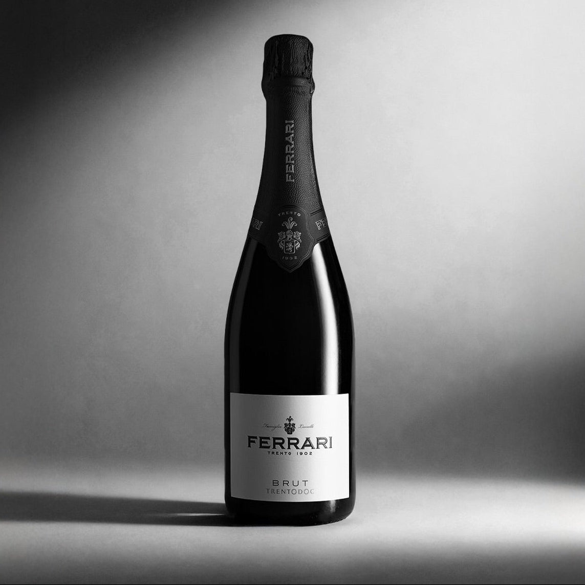 Load image into Gallery viewer, Ferrari Trento Brut Metodo Classico sparkling wine bottle with brand name on a dark background