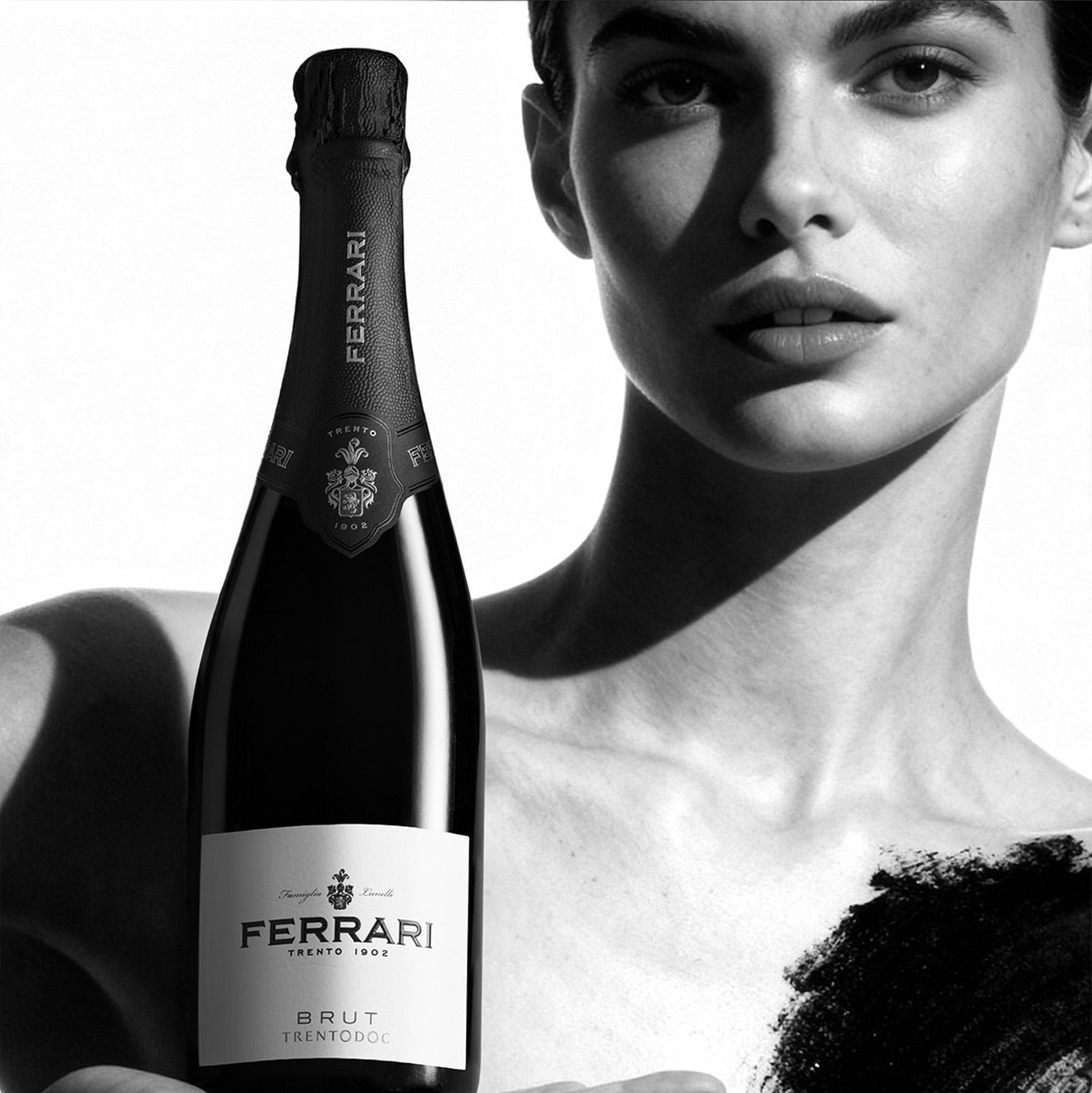 Load image into Gallery viewer, Bottle of Ferrari Trento Brut Metodo Classico sparkling wine held by a person against a white background