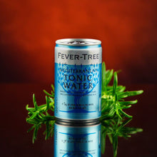 Load image into Gallery viewer, Fever-Tree Mediterranean tonic water can with fresh herbs on a reflective surface against a red background