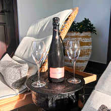 Load image into Gallery viewer, Bottle of Fleur de Champagne with two wine glasses on a small table outdoors.