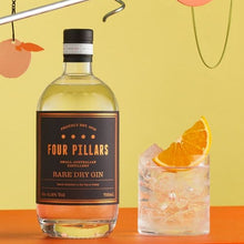 Load image into Gallery viewer, Four Pillars Rare Dry Gin bottle with a cocktail garnished with an orange slice on a colorful background
