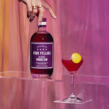 Load image into Gallery viewer, Four Pillars Bloody Shiraz Gin bottle with a cocktail garnished with a lemon slice on a pink background