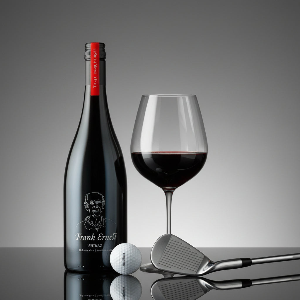 Load image into Gallery viewer, Frank Ernest Shiraz red wine bottle, glass with red wine, golf ball, and clubs on a reflective surface with a grey background