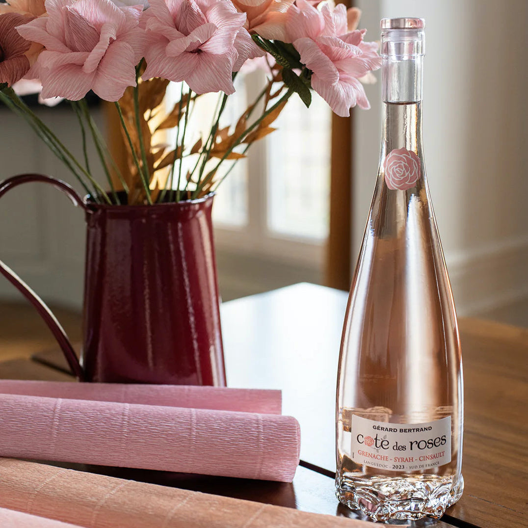 Load image into Gallery viewer, A bottle of Gerard Bertrand Côte des Rosés beside a vase a pink roses 