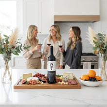 Load image into Gallery viewer, Three women in a kitchen enjoying a bottle of Glaetzer-Barossa-Valley-Bishop-Shiraz wine and a charcuterie board with Bishop wine.