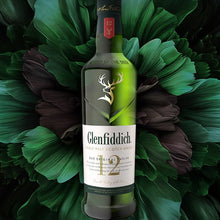 Load image into Gallery viewer, A bottle of whisky and some green artwork in the background.