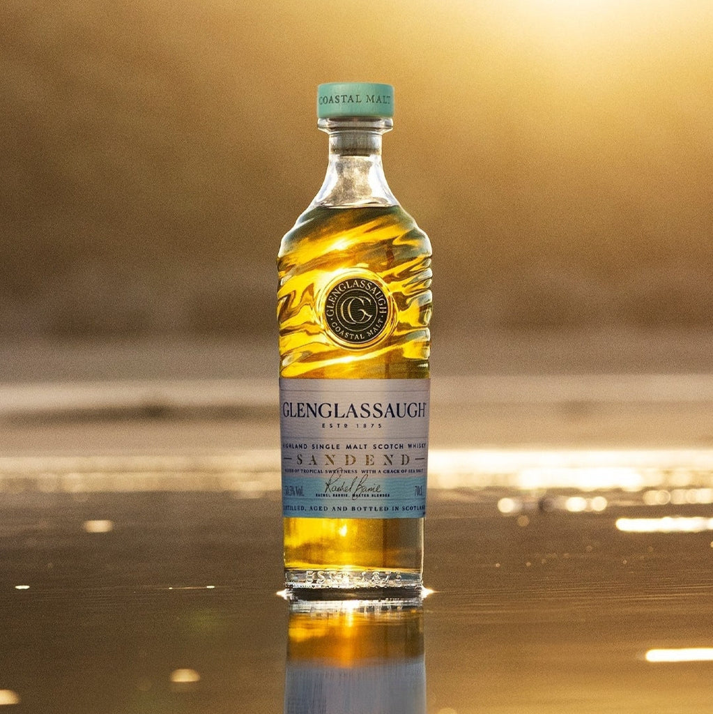 Bottle of Glenglassaugh Sandend whisky on a reflective surface with a blurred background