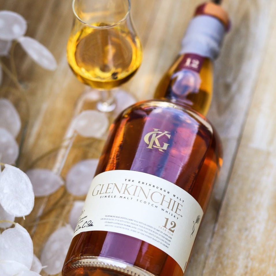 Load image into Gallery viewer, Glenkinchie whisky bottle laying down on a table with tumbler with neat whisky in it