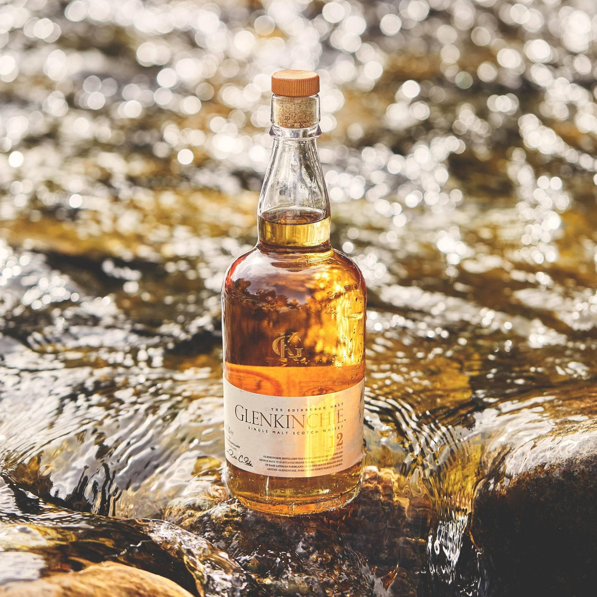 Load image into Gallery viewer, Glenkinchie whisky bottle standing on a stock in water