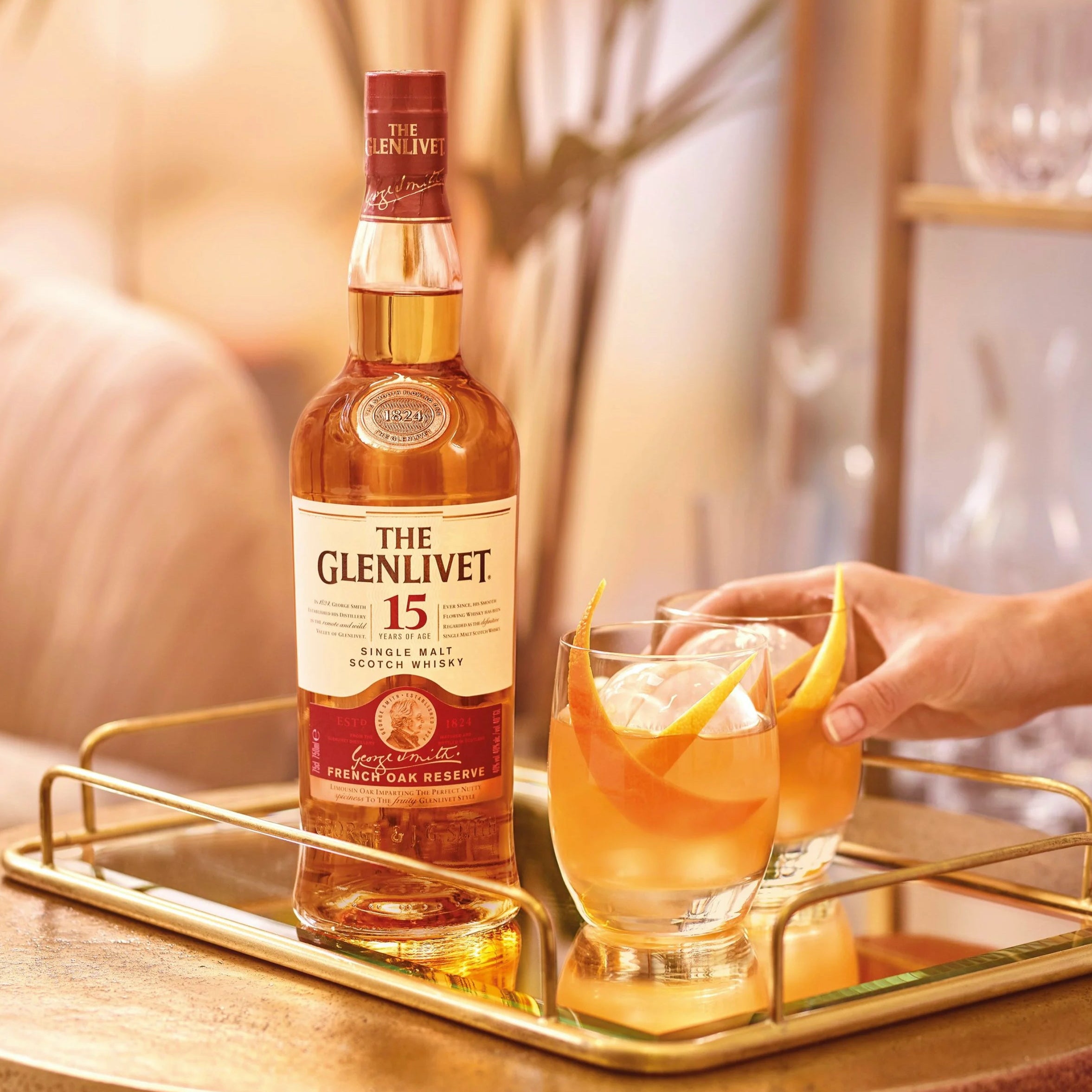 Load image into Gallery viewer, Glenlivet 15 year old bottle of whisky on a glass tray with two tumblers of cocktails