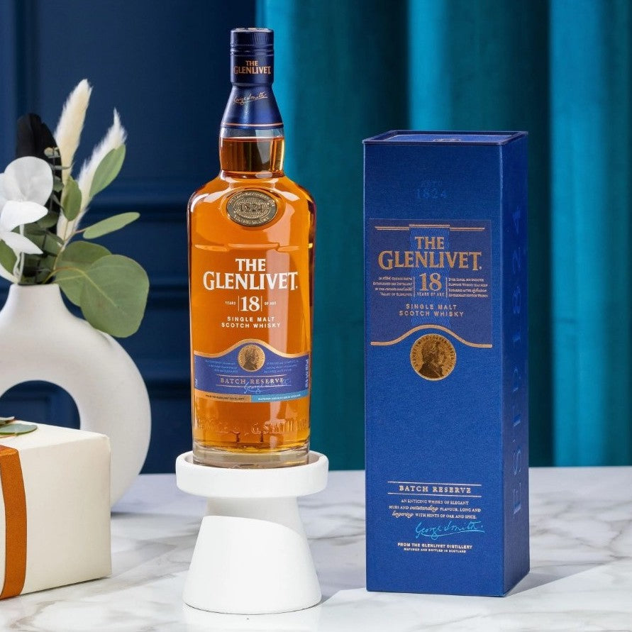 Load image into Gallery viewer, Glenlivet 18YO Single Malt Whisky on a marble table with some flowers in a vase in the background