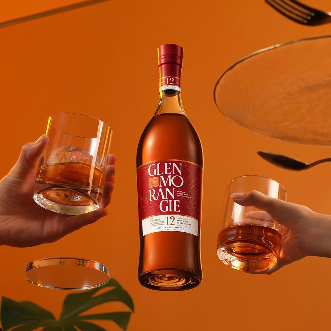 Load image into Gallery viewer, A bottle of Glenmorangie The Lasanta 12 Year Old Whisky with two glasses of neat whisky on an orange background