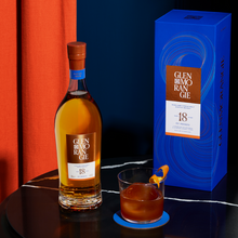 Load image into Gallery viewer, Glen Morangie 18 year old whisky bottle and box with a cocktail on a dark surface against an orange and blue background