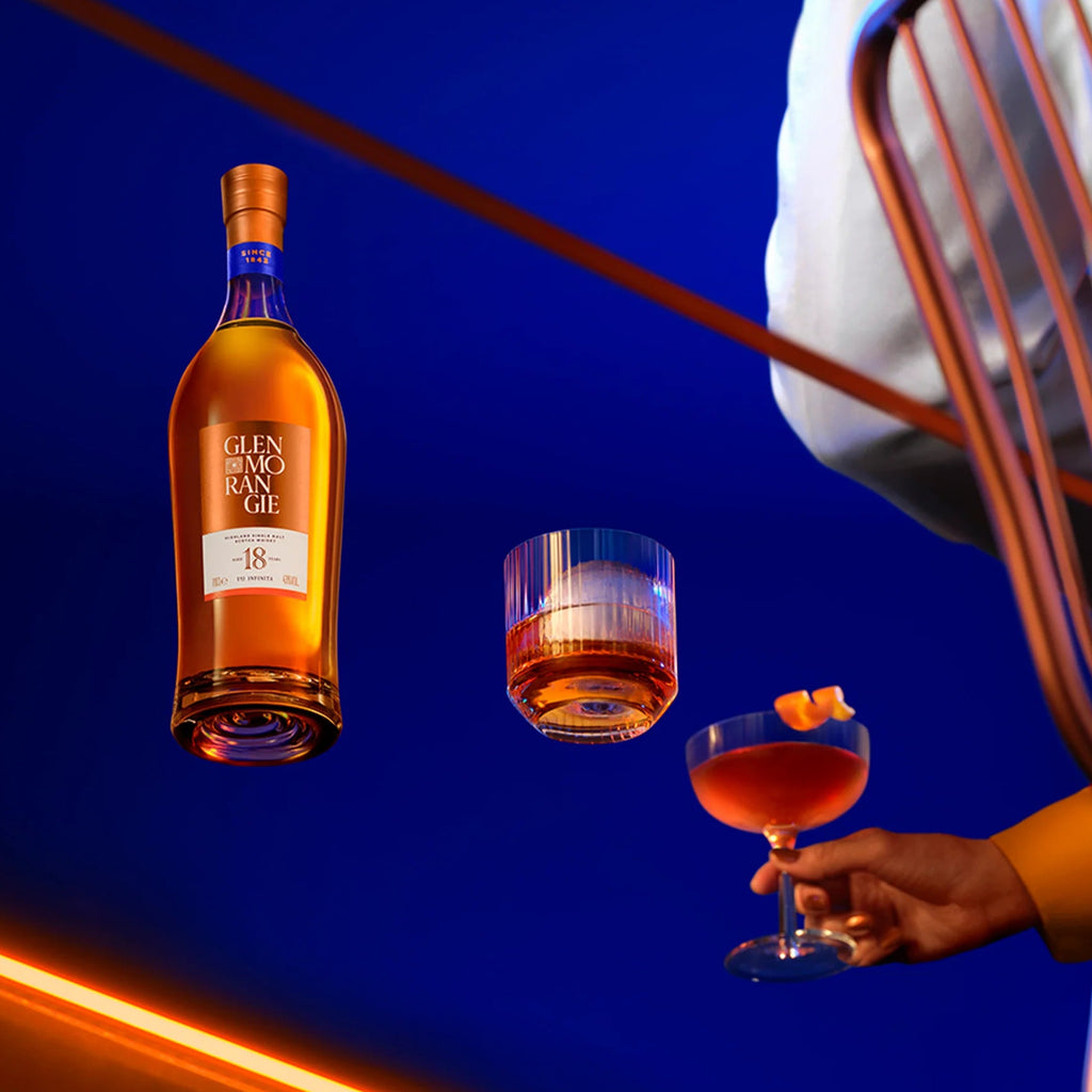 Bottle of Glenmorangie 18 year old whisky with two glasses on a blue background