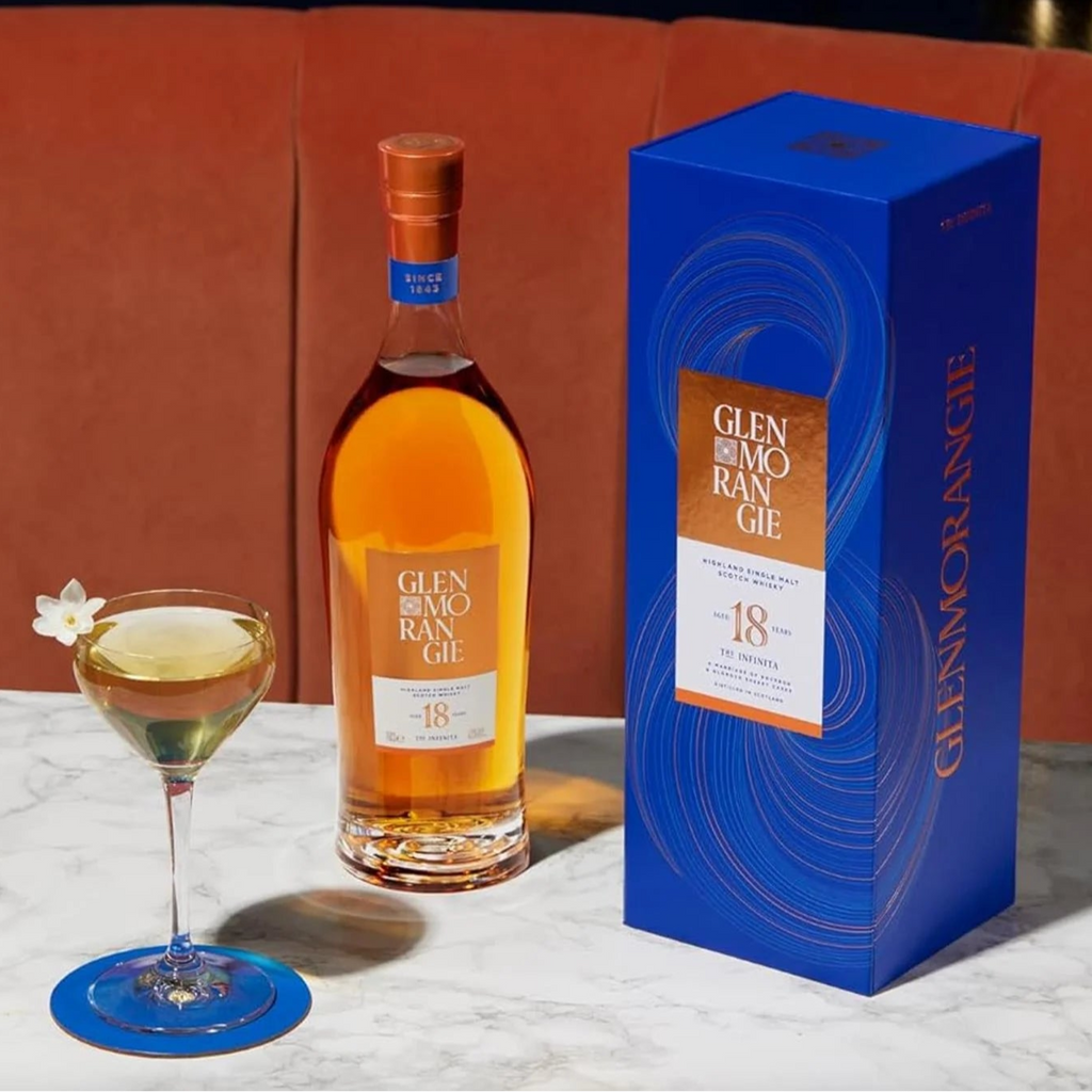 Glenmorangie 18-year-old whisky bottle and box with a cocktail on a marble surface.