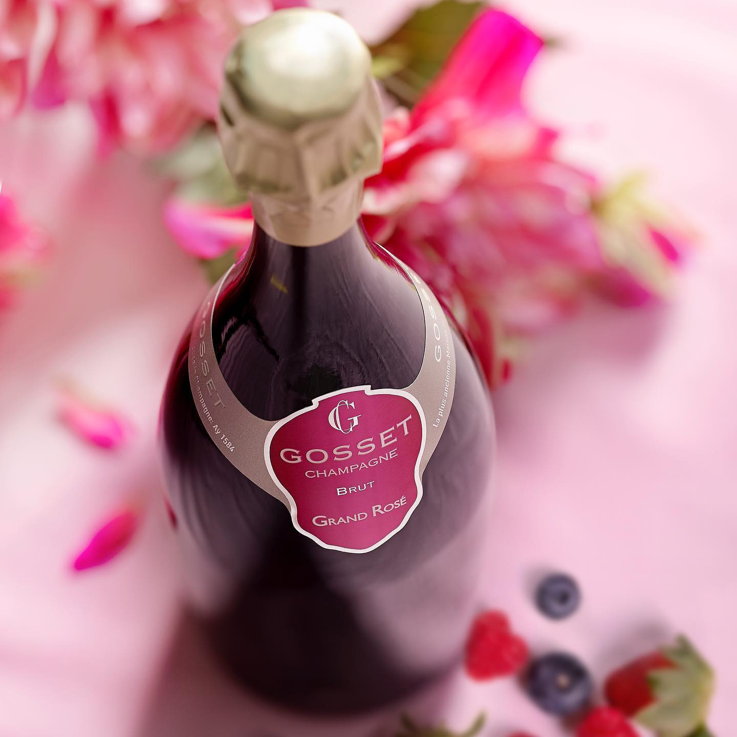 Load image into Gallery viewer, Gosset rosé champagne bottle with a pink label against a floral background