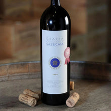 Load image into Gallery viewer, Bottle of Grappa Sassicaia with a cork on a wooden surface