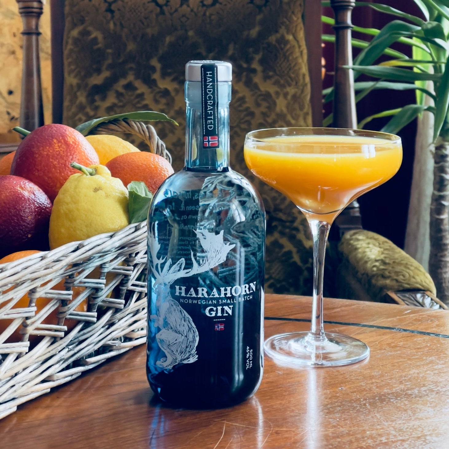 Load image into Gallery viewer, Bottle of Harahorn gin with a cocktail and fruit on a table.