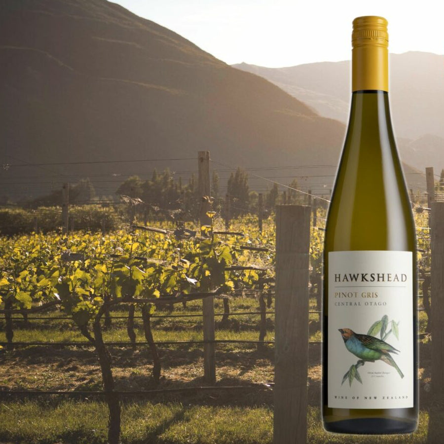 Bottle of Hawkeshead wine in a vineyard with mountains in the background