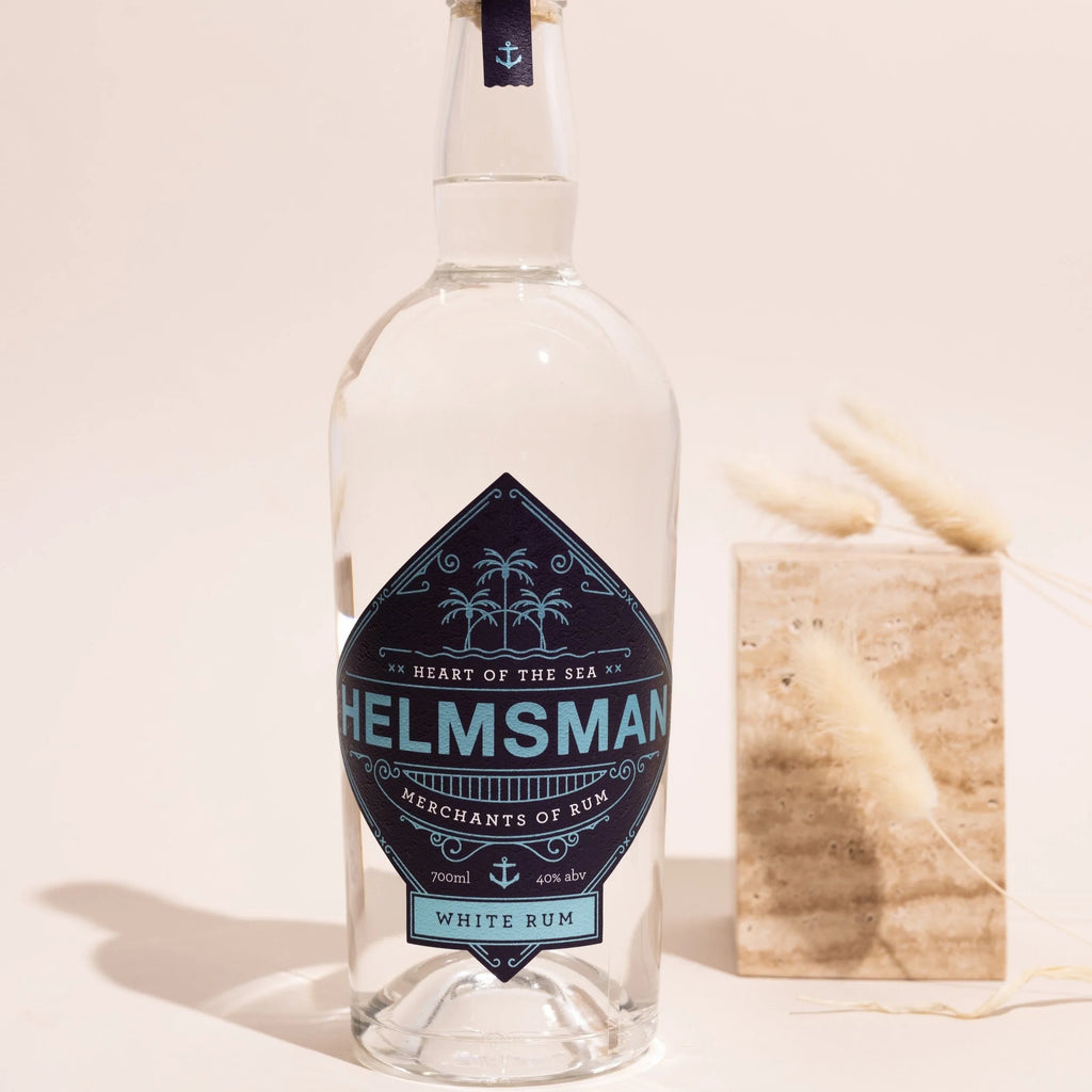 Bottle of Helmsman white rum with a blue label on a light background