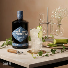 Load image into Gallery viewer, Hendrick's Lunar Gin bottle with a cocktail and garnishes on a table.