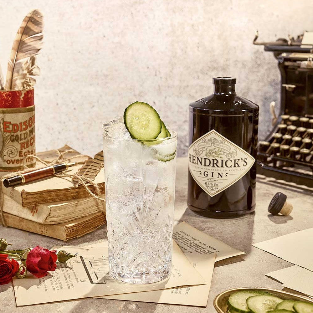Load image into Gallery viewer, Hendrick's gin bottle with a cocktail and vintage items on a table
