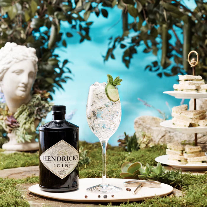 Load image into Gallery viewer, Hendrick's Gin bottle with a glass of gin and tonic in an outdoor setting.
