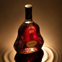 Load image into Gallery viewer, Hennessy bottle with a warm glow on a reflective surface
