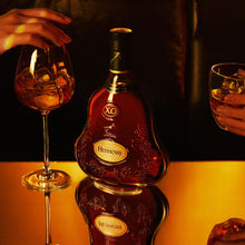Load image into Gallery viewer, Hennessy bottle with two glasses on a reflective surface