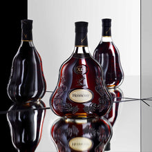 Load image into Gallery viewer, Hennessy XO cognac bottle on a reflective surface with a black and white background
