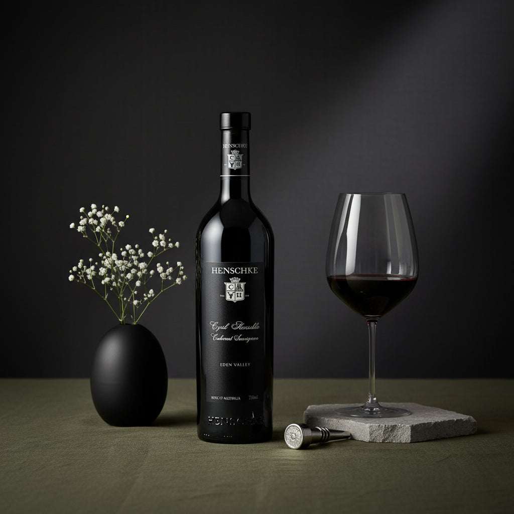 Bottle of Henschke Cyril Cabernet Sauvignon wine with a glass and decorative elements on a dark background