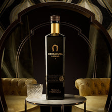 Load image into Gallery viewer, Herradura tequila bottle on a table with a decorative background