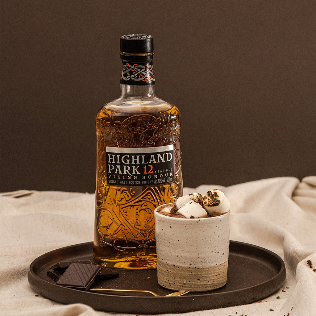 Bottle of Highland Park 12 whisky on a tray with a cup of hot chocolate.