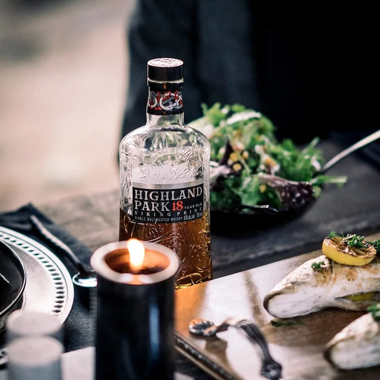 Load image into Gallery viewer, A bottle of Highland Park 18YO Viking Pride Whisky on a table with some food
