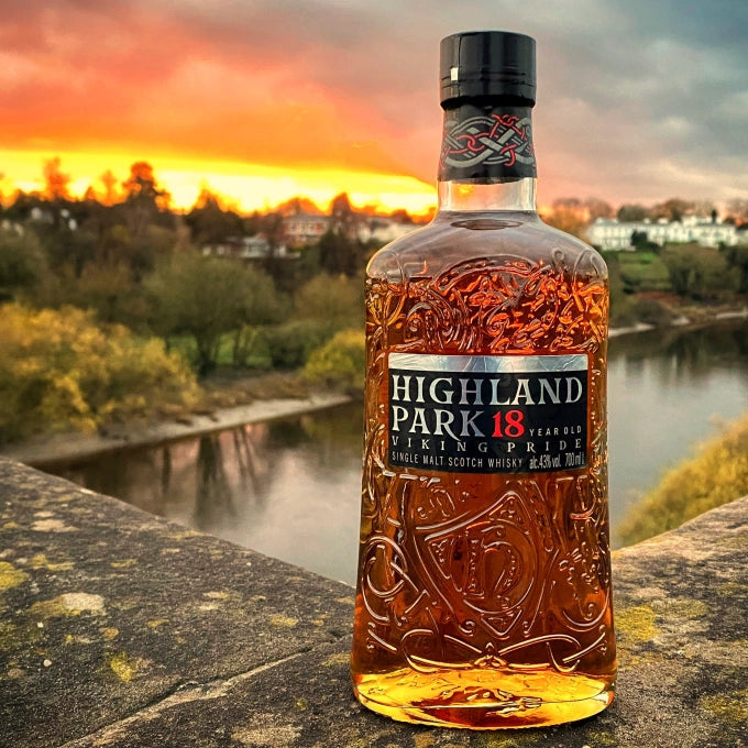 Highland Park whisky bottle with a scenic background