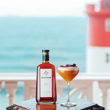 Load image into Gallery viewer, A bottle of gin and a cocktail in front of a lighthouse by the sea.