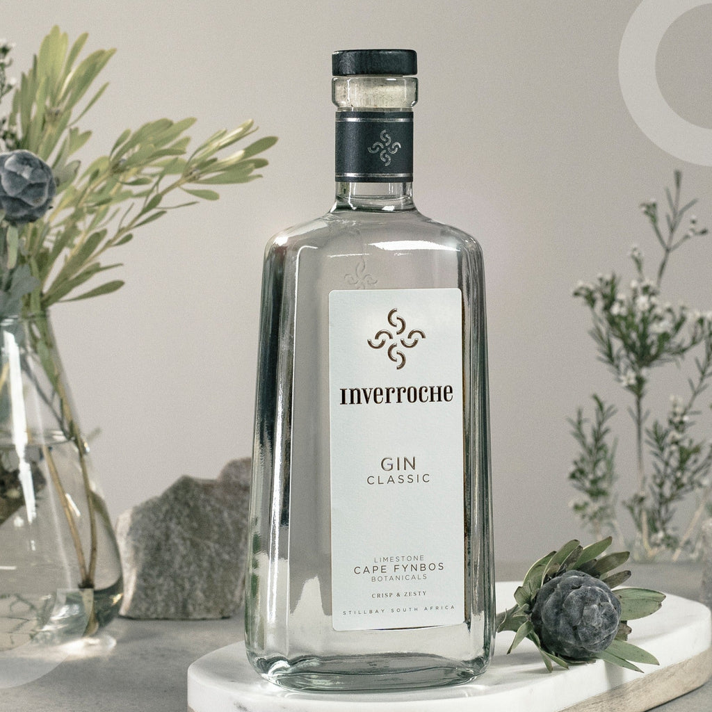 Inverrhoche Gin bottle on a marble coaster with decorative plants in the background