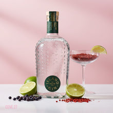 Load image into Gallery viewer, Bottle of Island Original Gin with limes, berries, and a cocktail glass on a pink background