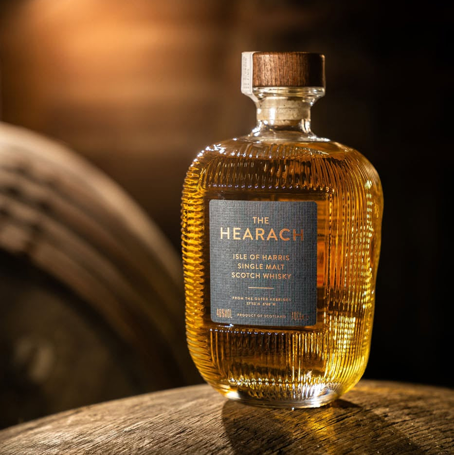 Load image into Gallery viewer, Bottle of The Hearach single malt whisky on a wooden barrel with a blurred background