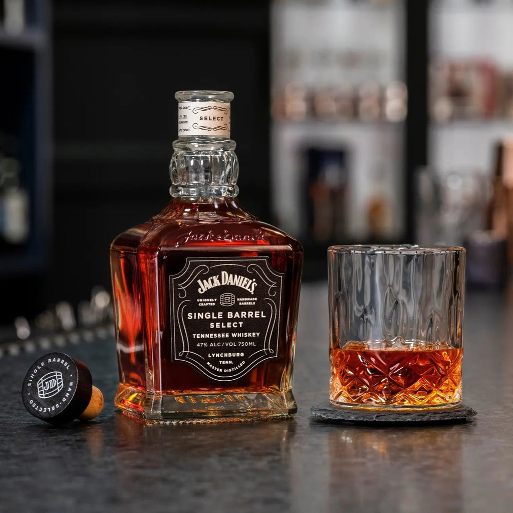 Jack Daniel's whiskey bottle and glass on a bar counter with blurred shelves in the background