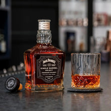 Load image into Gallery viewer, Jack Daniel&#39;s whiskey bottle and glass on a bar counter with blurred shelves in the background