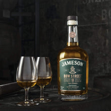 Load image into Gallery viewer, A bottle of Jameson whiskey on a barrel with two glasses of whiskey in them with a  dark grey background 
