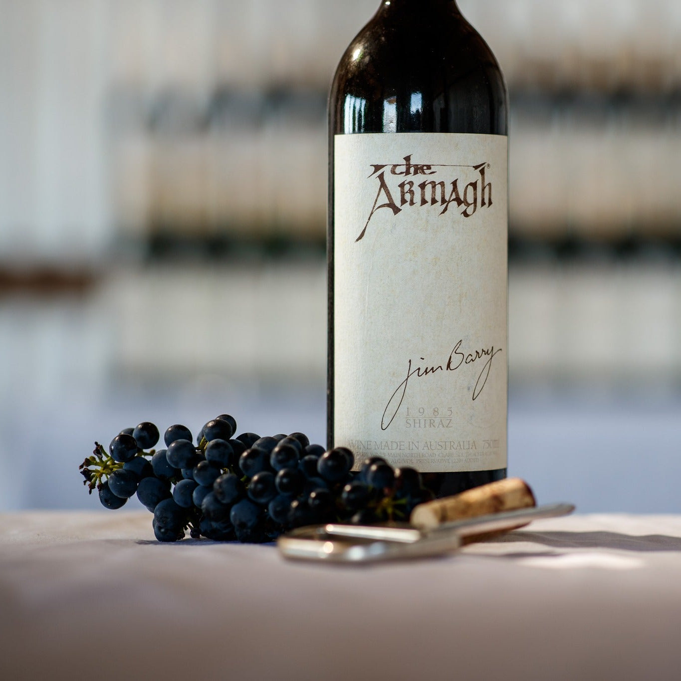 Load image into Gallery viewer, Jim-Barry-The-Armagh-Shiraz wine bottle with grapes and a spoon on a table, blurred background